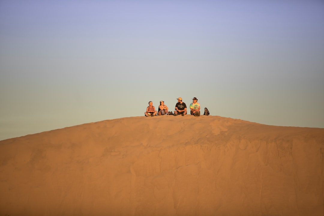 Caravan across dunes under warm sunset light